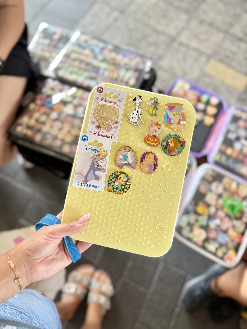 A pin trading book and pins laid out